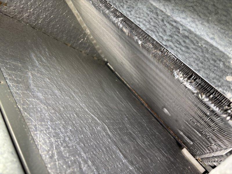 Responded to service call for 8-year-old air conditioning system experiencing reduced efficiency following recent duct cleaning. Upon inspection, found evaporator coil contaminated with fibers and debris that had been dislodged during the duct cleaning process and subsequently drawn into the coil assembly. Performed thorough evaporator coil cleaning to remove accumulated fibers, dust, and particulate matter from the aluminum fins and heat exchange surfaces. Documented pre-cleaning condition showing significant debris accumulation on coil fins. Restored proper airflow through the coil assembly and verified system operation. Discussed preventive maintenance program options with customer.