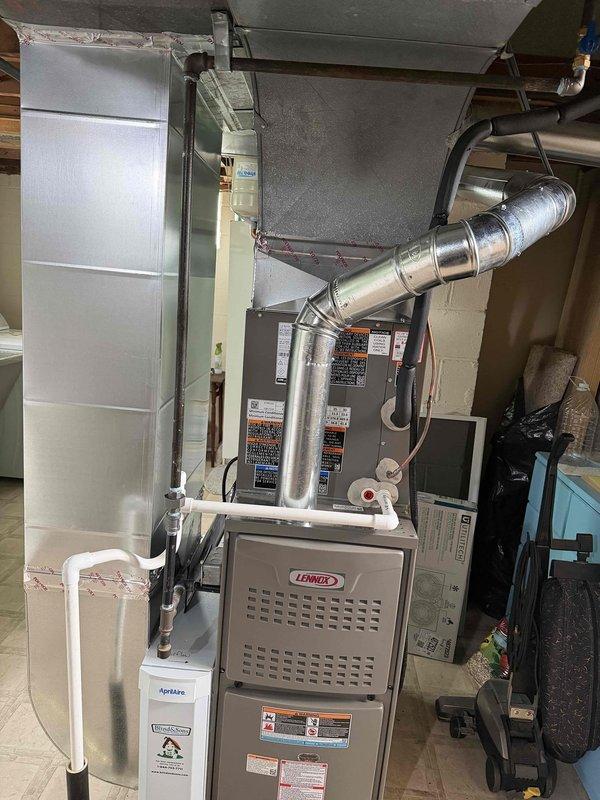 Completed full HVAC system installation including an 80% efficiency Lennox furnace and air conditioning unit in residential basement utility room. Installed new ductwork with metallic elbow joints and connections, integrated humidifier system to furnace, and ensured proper venting with PVC piping. Installed Kidde carbon monoxide alarm in living area per safety code requirements, tested all equipment for proper operation, and verified system functionality upon completion.