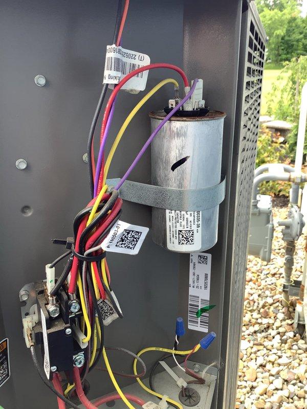 Responded to service call for two AC units, with one unit producing loud banging noise upon startup. Inspected outdoor condensing unit and internal electrical components. Examined capacitor assembly, wiring connections, and associated electrical terminals. Capacitor showed signs of weathering consistent with outdoor installation but appeared operational. Verified proper wire connections at capacitor terminals and wire nut junctions. Documented unit condition and component configuration with photographs for service records.