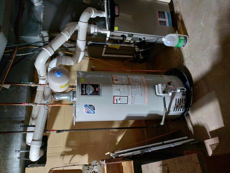 Removed existing water treatment system and reconfigured overhead water lines by plumbing them together with copper piping to restore proper water flow. Performed complete flush and fill service on the water heater to remove sediment buildup and replaced the thermal expansion tank to ensure proper system pressure regulation. All work completed using truck stock materials with new copper pipe routing visible in utility area.