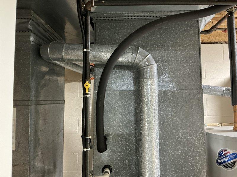 Provided estimate for complete HVAC system replacement in medium-sized residential property. Assessed existing York high-efficiency outdoor condensing unit showing weathering and outdoor exposure, along with basement ductwork configuration featuring galvanized steel supply runs with curved elbow transitions and support brackets. Quoted Lennox vertical upflow/downflow gas furnace and air conditioning system suitable for 1500-3000 square foot heating and cooling application with natural gas or propane fuel source and basement installation location.