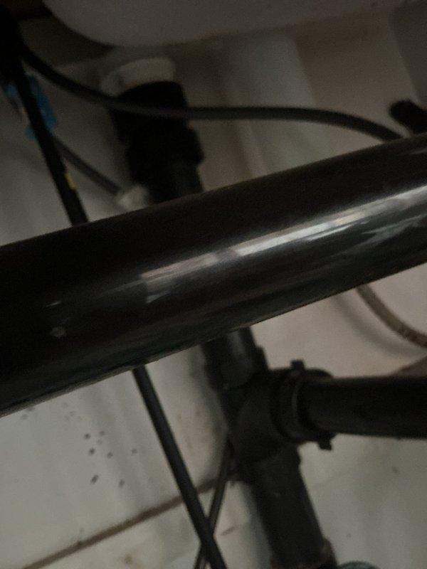 Responded to kitchen sink drain clog. Inspected plumbing assembly beneath sink, including chrome drain pipe, P-trap, and supply lines. Cleared blockage from drain system and verified proper water flow through pipes. All plumbing components functioning properly upon completion.