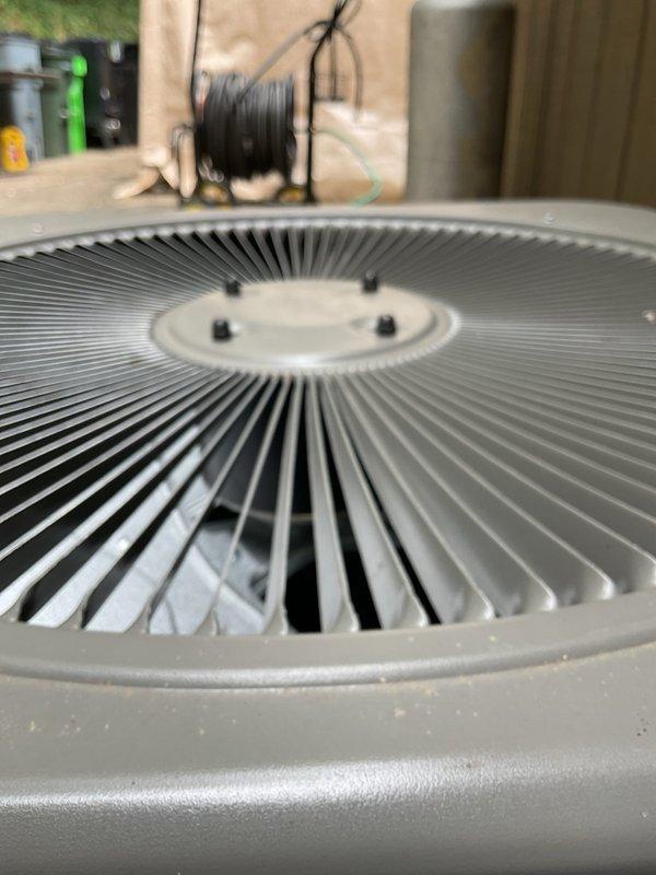 Responded to service call for air conditioning condenser unit experiencing excessive noise levels approximately 11 months after installation. Upon arrival, confirmed system was maintaining proper cooling capacity despite increased operational sound. Performed thorough inspection of condenser unit including examination of fan assembly, motor mounts, and electrical components. Inspected control panel containing capacitor and contactor with associated wiring connections. Evaluated fan grille, blades, and motor operation for potential sources of noise including loose components, bearing wear, or mounting issues. Documented equipment condition through photographic records showing electrical panel configuration and condenser fan assembly. System continues to operate and cool effectively.