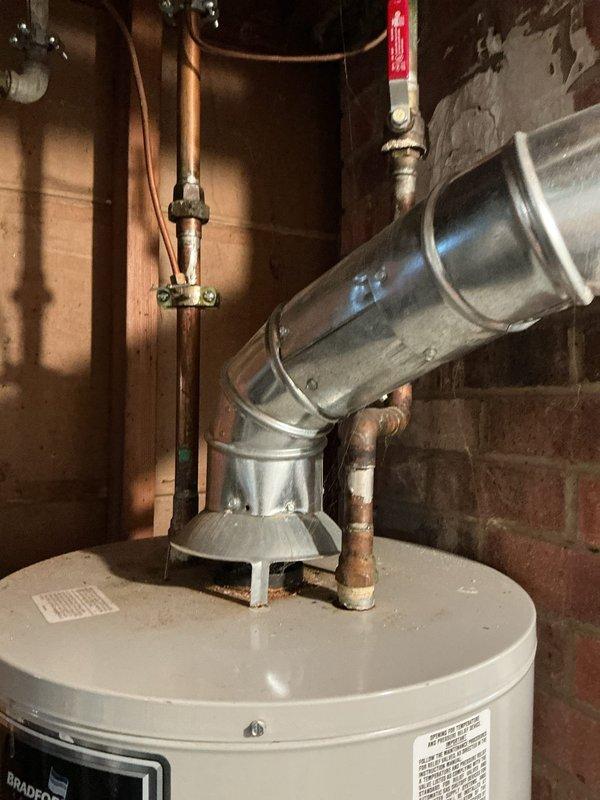 Responded to service call for reported water heater leak. Conducted thorough inspection of residential tanked water heater installation, including examination of tank condition, plumbing connections, shutoff valves, and venting system. Documented existing installation with photographs showing water heater unit, copper supply lines with shutoff valves, galvanized venting ductwork, and associated plumbing components in basement utility area. Assessed system for source of leak and overall condition to provide estimate for necessary repairs or replacement.