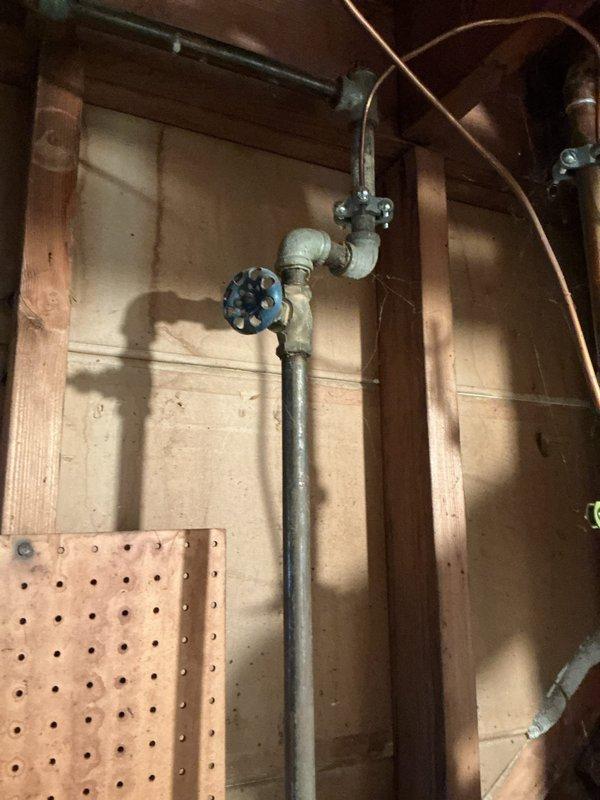 Responded to service call for reported water heater leak. Conducted thorough inspection of residential tanked water heater installation, including examination of tank condition, plumbing connections, shutoff valves, and venting system. Documented existing installation with photographs showing water heater unit, copper supply lines with shutoff valves, galvanized venting ductwork, and associated plumbing components in basement utility area. Assessed system for source of leak and overall condition to provide estimate for necessary repairs or replacement.