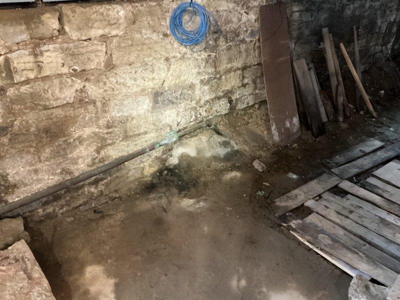 Responded to main drain backup issue at residential property. Upon inspection of crawl space and basement areas, assessed drainage system including visible PVC/ABS piping network and identified source of backup. Documented extensive moisture damage and standing water on basement floor, along with deteriorated foundation conditions showing long-term water exposure and efflorescence on masonry walls. Evaluated structural support systems and utility routing in crawl space to access affected drain lines. Cleared main drain obstruction and restored proper flow to system. Verified all fixtures draining correctly upon completion.