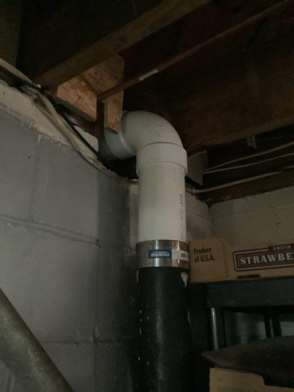 Responded to warranty callback for persistent toilet leak. Upon inspection, confirmed previous repair was unsuccessful due to improper toilet flange height causing seal failure. Assessed PVC drainage system configuration in basement area, including vertical stack and horizontal connections. Identified flange installation issue requiring correction to achieve proper toilet mounting and watertight seal. Documented plumbing infrastructure including drainage lines, fittings, and connections for repair planning.