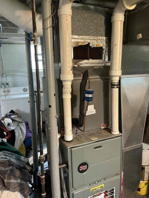 Conducted on-site evaluation and prepared estimate for complete air conditioning system replacement at single-family residence. Existing 16-year-old outdoor condenser unit and indoor evaporator coil system assessed for age-related failure and inefficiency. Documented current Ruud furnace installation with existing evaporator coil mounted above, photographed outdoor condensing unit positioned on grade-level pad with electrical disconnect and refrigerant line set connections, and reviewed overall system configuration to provide comprehensive replacement proposal for new cooling system.