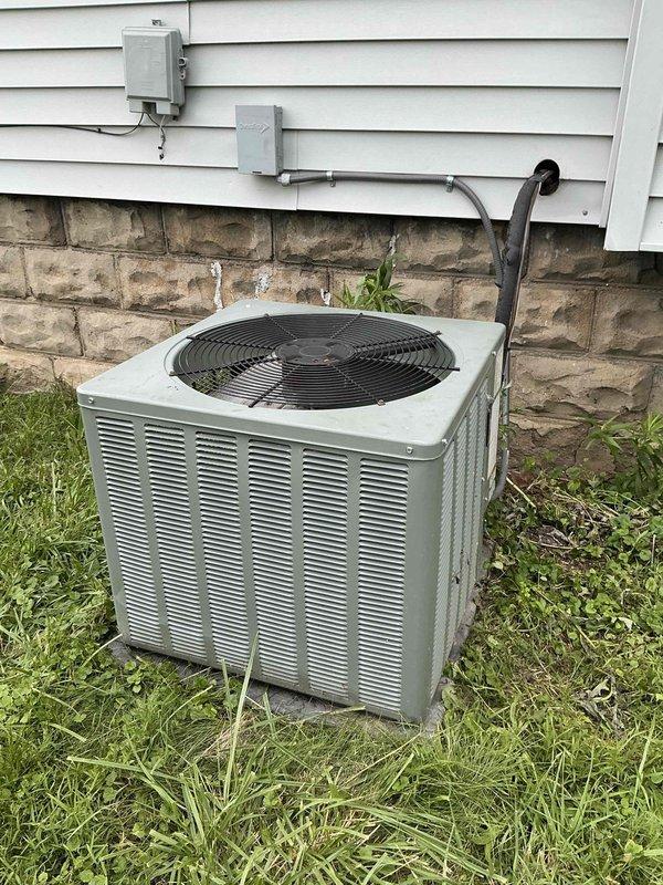 Conducted on-site evaluation and prepared estimate for complete air conditioning system replacement at single-family residence. Existing 16-year-old outdoor condenser unit and indoor evaporator coil system assessed for age-related failure and inefficiency. Documented current Ruud furnace installation with existing evaporator coil mounted above, photographed outdoor condensing unit positioned on grade-level pad with electrical disconnect and refrigerant line set connections, and reviewed overall system configuration to provide comprehensive replacement proposal for new cooling system.