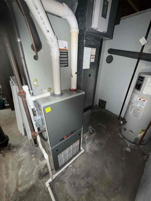 Completed scheduled BS-MVP cooling maintenance visit on 13-year-old residential air conditioning system. Arrived at 8am as first appointment and performed comprehensive inspection of HVAC equipment located in basement mechanical room. Evaluated furnace unit with associated PVC condensate drain lines and intake/exhaust venting, verified refrigerant line connections, and assessed overall system operation. Documented equipment condition through photographic records, noting visible staining and discoloration on ductwork components indicating age-related wear. All routine maintenance tasks completed per service protocol, system operating within normal parameters.