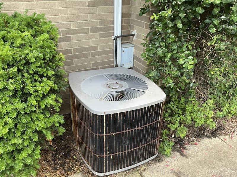 Conducted estimate for complete HVAC system replacement including outdoor condensing unit and attic-mounted air handler. Inspected existing aging condenser unit showing significant weathering, oxidation, and rust staining on exterior panels and grilles. Evaluated current system configuration including electrical disconnect, refrigerant lines, and condensate drainage. Documented equipment condition and access requirements for attic air handler installation scheduled for morning appointment.