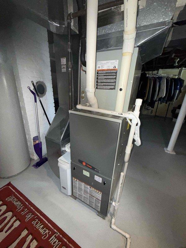 Completed BS-MVP cooling maintenance visit on residential HVAC system. Performed comprehensive inspection of outdoor condensing unit, observing dual-capacitor component with multiple wire connections showing normal operational wear and outdoor exposure. Inspected indoor air handler and furnace assembly in basement mechanical room, verified proper PVC condensate drain routing and system configuration. All equipment found operating within normal parameters with no immediate service needs identified during this preventive maintenance visit.