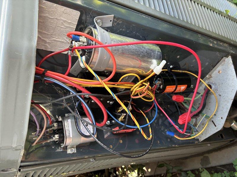 Responded to service call for outdoor air conditioning condenser unit experiencing operational issues. Upon inspection, diagnosed failed dual run capacitor affecting both compressor and condenser fan motor performance. Removed access panel to electrical compartment and disconnected power supply. Replaced defective capacitor with new OEM-spec component, ensuring proper microfarad ratings for both compressor and fan circuits. Verified all electrical connections, secured wiring, and tested unit operation. System restored to full functionality with normal amperage draws and proper cooling cycle operation.