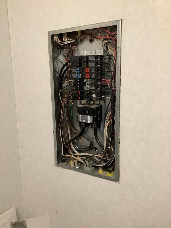 Responded to service call for electrical panel malfunction following lightning strike. Upon arrival, performed comprehensive diagnostic evaluation of main distribution panel and exterior meter assembly. Inspection revealed compromised circuit breakers and potential surge damage to panel components. Documented existing conditions including mixed breaker configuration with standard single-pole and double-pole breakers, junction connections at panel base, and exterior meter housing with associated disconnect box. Assessed wiring integrity throughout panel including all branch circuit conductors entering from top and bottom of enclosure. Identified multiple circuits requiring attention due to lightning-related electrical surge. Provided diagnostic findings and repair recommendations to customer for proper restoration of electrical system functionality and safety compliance.