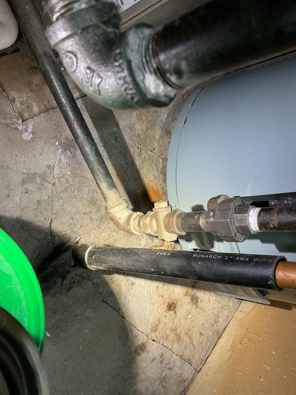 Conducted on-site assessment for water heater replacement in residential property. Evaluated existing water heater installation located in basement utility area, noting current equipment configuration including cylindrical tank unit, associated supply and discharge piping, and connection points. Inspected plumbing infrastructure including metal threaded fittings, insulated supply lines, and existing foam sealant applications around pipe penetrations. Assessed utility compartment access point with interior plumbing valves and controls accessible through cabinet opening in main living space. Documented current installation conditions including pipe routing, floor space clearances, and structural considerations for new unit installation. Photographed existing equipment setup, connection methodology, and access points to provide comprehensive documentation for replacement proposal. Provided detailed estimate for complete water heater replacement including removal of existing unit, installa