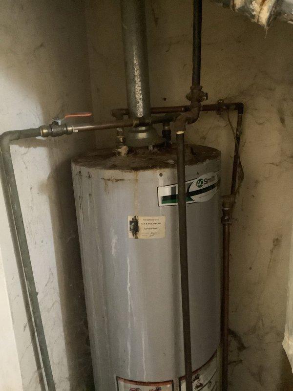 Responded to service call for 8-year-old natural gas water heater with pilot light failure. Upon arrival, inspected A.O. Smith tank-style water heater located in basement utility area. Confirmed pilot would not ignite or remain lit, with no status indicator light flashing on gas control valve. Accessed burner assembly and thermocouple to diagnose ignition system failure. Given the age of the unit, visible exterior rust deterioration, and pilot safety system malfunction, determined that thermocouple replacement or gas valve replacement would be necessary to restore proper operation.