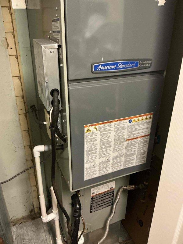 Provided estimate for American Standard Freedom 95 condensing furnace requiring heat exchanger replacement and conversion from liquid propane to natural gas operation. Customer converting entire home to natural gas fuel source. Documented existing equipment condition and installation location in basement utility area with photos showing current configuration, including exterior HVAC components and interior furnace unit with proper venting and drainage systems in place.
