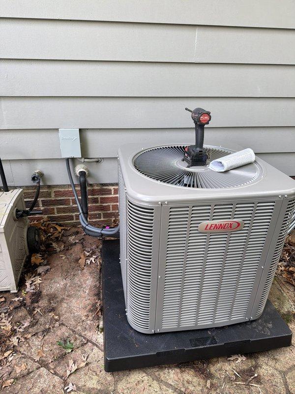 Completed installation of new Lennox air conditioning system and furnace, replacing severely deteriorated existing equipment. Removed old rusted HVAC unit that exhibited extensive corrosion and environmental damage. Installed new Lennox condenser unit on exterior concrete pad with proper refrigerant line routing through building envelope. Connected copper refrigerant lines with appropriate insulation and installed service port for future maintenance access. Mounted electrical disconnect box on exterior wall per code requirements. Routed all refrigerant lines from outdoor condenser unit into building. Installation represents approximately 90% completion of full system replacement project. Tankless water heater installation to be completed by plumbing department on separate work order.