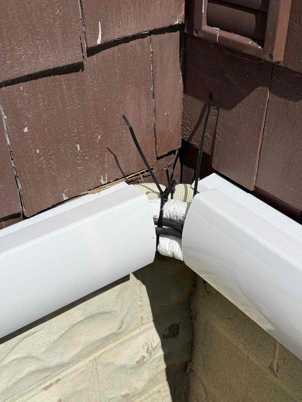 Returned to complete warranty repair by installing pipe couplings on vertical PVC vent penetration through roof and at interior junction point to prevent future leaks. Secured all piping with proper strapping and verified watertight connections at roof penetration and interior corner assembly.