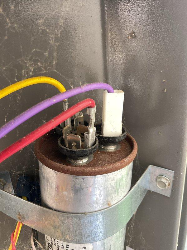Completed MVP cooling maintenance visit on residential HVAC system. Inspected and photographed dual capacitor with proper wire connections, verified secure mounting bracket, and noted minor moisture accumulation on unit housing consistent with normal condensation. Performed airflow measurement at supply register using digital meter to confirm proper system performance and adequate cooling delivery throughout occupied space.