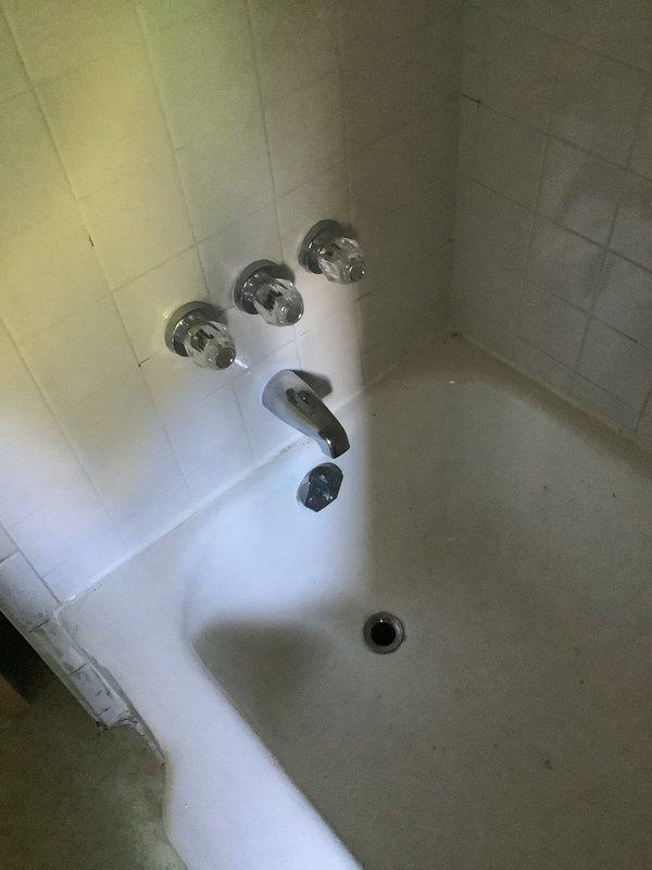 Installed a new 3-handle Moen shower valve with integrated mixing valve in bathroom. Work required accessing plumbing through wall cavity, running new copper supply lines, and mounting chrome fixtures including three control knobs, tub spout, and diverter valve above existing bathtub. Installation completed with all fixtures operational and wall access properly sealed.