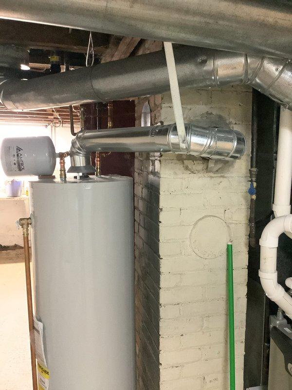 Responded to warranty callback regarding water heater installation from 2023 that was flagged during home inspection as not meeting code requirements. Upon arrival, performed comprehensive inspection of the unit and all associated components including copper piping connections, expansion tank, venting system, and mounting configuration. Documented current installation conditions with detailed photography showing water heater positioned against painted masonry wall with copper supply lines, brass fittings, expansion tank, and galvanized metal ductwork connections. Verified all plumbing connections, reviewed clearances, checked TPR valve discharge piping, examined venting configuration, and assessed compliance with current plumbing code standards. Installation found to meet applicable code requirements at time of original installation.