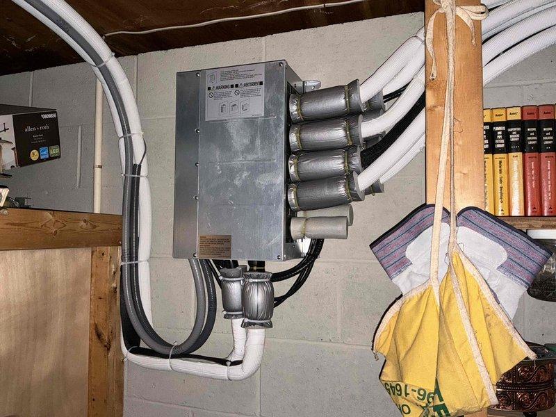 Completed on-site evaluation for additional mini split unit installation in residential property. Assessed existing electrical infrastructure including current disconnect panel, conduit routing, and available capacity to support new system. Documented installation location and determined optimal placement for indoor air handler unit in finished living space with wood-paneled walls. Photographed existing mini split components and electrical connections to plan integration of additional unit into current HVAC configuration.