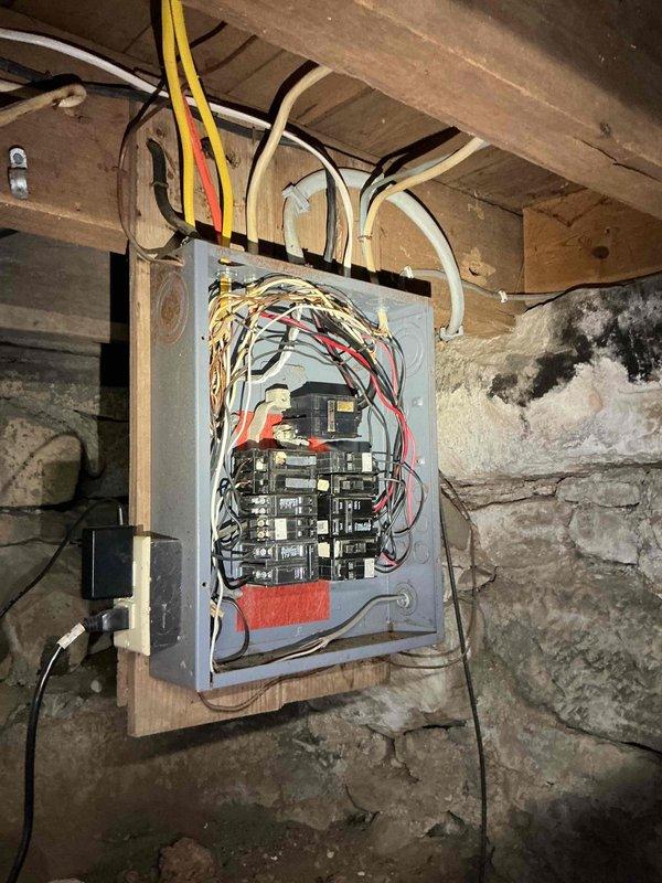 Conducted on-site electrical assessment for 10kW standby generator installation at a small residential property with 100-amp service panel located in basement. Evaluated existing electrical infrastructure, documented current panel configuration and available capacity, and photographed panel conditions including wiring arrangement and surrounding environment to determine feasibility for basic power backup system covering essential circuits.