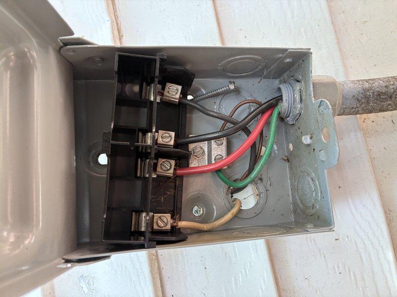Replaced defective electrical disconnect box for HVAC system. Removed old gray metal enclosure and installed new disconnect with proper fused switch mechanism. Reconnected all electrical wiring including power conductors and ground wire to appropriate terminals, verified secure connections, and confirmed proper operation of disconnect switch.