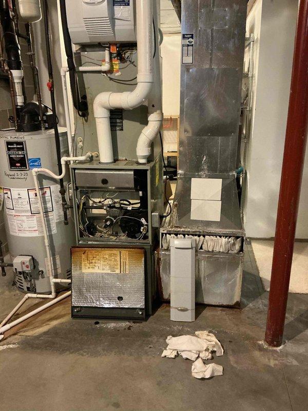 Responded to no cooling call and conducted comprehensive assessment of existing HVAC system including outdoor air conditioning unit and indoor furnace equipment. Documented current equipment conditions with detailed photography of both exterior condensing unit mounted on gravel pad and interior basement furnace system with exposed components. Prepared complete replacement estimate for furnace and air conditioning system to address cooling failure and overall system performance concerns.