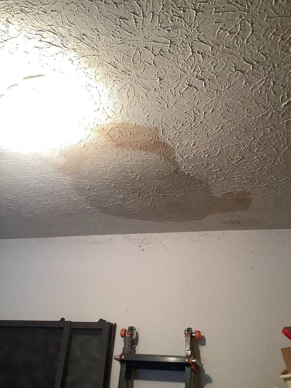 Responded to report of water leak in garage ceiling suspected to originate from dishwasher above. Upon inspection, identified active water staining and moisture intrusion on ceiling surface with visible brownish discoloration indicating ongoing or recent leak. Documented damage through photographic evidence showing extent of water penetration and affected ceiling area. Scheduled follow-up appointment to perform further diagnostic assessment and determine exact source of leak, whether from dishwasher supply line, drain connection, or other plumbing fixture above affected area.
