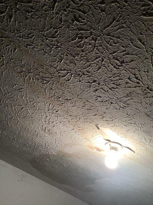 Responded to report of water leak in garage ceiling suspected to originate from dishwasher above. Upon inspection, identified active water staining and moisture intrusion on ceiling surface with visible brownish discoloration indicating ongoing or recent leak. Documented damage through photographic evidence showing extent of water penetration and affected ceiling area. Scheduled follow-up appointment to perform further diagnostic assessment and determine exact source of leak, whether from dishwasher supply line, drain connection, or other plumbing fixture above affected area.