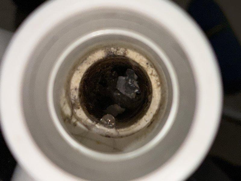 Responded to service call for 6-year-old air conditioning system operating below optimal performance. Upon inspection, found dirty air filter restricting airflow and condensate drain line showing significant buildup of biological matter and mineral deposits. Replaced air filter with new pleated media filter and cleared condensate drain line to restore proper drainage and prevent potential water damage or system shutdown.