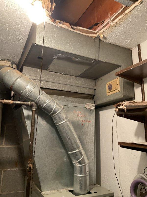 Conducted site assessment of existing HVAC ductwork system in basement utility area to provide estimate for temporary duct removal to facilitate plumbing pipe replacement. Documented current ductwork configuration including main trunk line and plenum connections to Trane furnace unit. Photographed ductwork layout, structural clearances, and existing ceiling damage to determine scope of removal and reinstallation work required for plumbing contractor access.