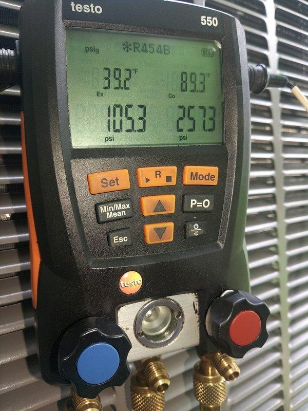 Completed installation of a 90% efficiency furnace and air conditioning system. System was properly charged with R454B refrigerant to manufacturer specifications, with pressures verified at 105.3 psi high side and 25.78 psi low side, and temperatures reading 39.2°F and 89.3°F on digital manifold gauges. Installed brass ball valve with blue handle on water supply line for proper system isolation and maintenance access.