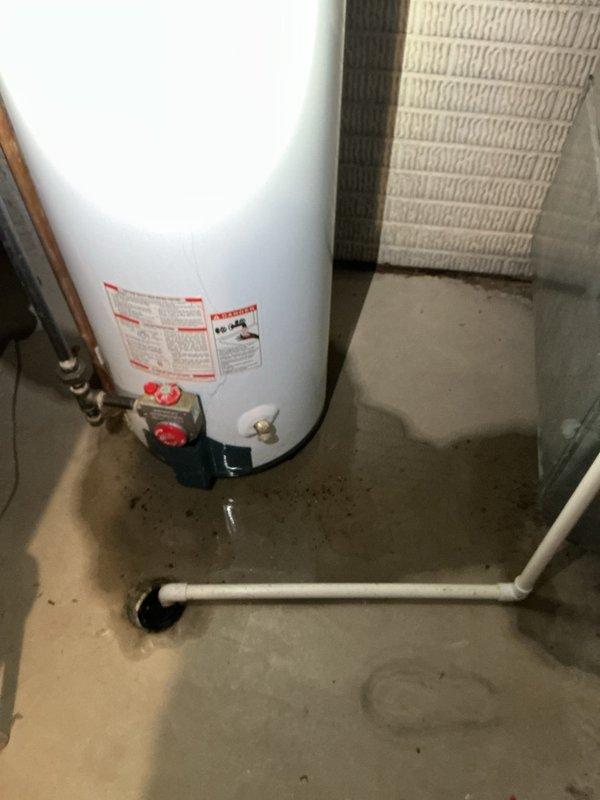 Responded to emergency water heater replacement request for a 10+ year old natural gas unit that had failed with the bottom of the tank compromised. Assessed the existing installation, documented the damaged water heater and surrounding plumbing configuration including copper supply lines, brass valves, expansion tank, and galvanized flue venting system. Provided quote for replacement unit installation with expedited service timeline as requested, including pricing options for Rheem brand equipment to meet customer preferences.
