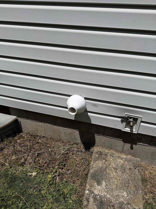 Completed installation of a 93% efficiency furnace, air conditioning system, and condensate pump at a mobile home structure. Installed new electrical disconnect with dual 25-amp fuses and contactor assembly to provide proper power supply and overcurrent protection for the outdoor condensing unit. Routed condensate drain line through exterior siding with proper PVC piping and elbow configuration to ensure adequate drainage away from the structure foundation.