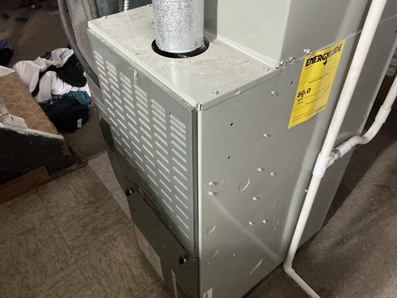 Completed on-site estimate for residential HVAC system replacement, evaluating existing 80% AFUE furnace unit located in basement and air conditioning system with evaporator coil installed in interior space. Documented current equipment conditions, measured system specifications, photographed existing installations including furnace cabinet, ductwork connections, refrigerant line sets, and provided replacement options for both heating and cooling equipment or air conditioning system only per customer request.
