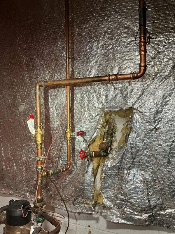 Conducted comprehensive water analysis consultation for residential property built in the mid-to-late 1980s. Evaluated existing plumbing infrastructure including copper piping system with brass shut-off valves and assessed current water quality conditions. Inspected utility area plumbing installation showing aged components with mineral buildup and discoloration on existing valve assembly, indicating hard water issues. Discussed whole-home water treatment solutions including water softener options and filtration systems appropriate for the property's age and plumbing configuration. Provided detailed information on available water conditioning equipment and installation requirements. Documented existing plumbing conditions with photographs for treatment system planning purposes.