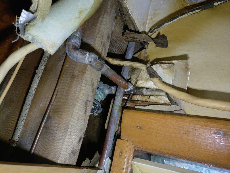 Responded to water leak emergency in residential bathroom. Upon inspection, identified burst pipe under bathroom sink causing active water damage. Accessed crawl space to locate source of leak in supply line. Isolated affected section of corroded copper piping showing significant deterioration and oxidation. Shut off water supply to prevent further damage. Capped off compromised pipe section and installed replacement piping with proper fittings and connections. Tested all connections for leaks and verified proper water pressure restoration to bathroom fixtures. Confirmed vanity area and surrounding plumbing systems functioning correctly with no additional leaks detected.