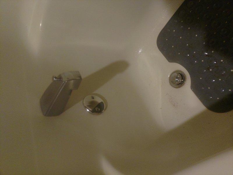 Removed existing bathtub shoe drain assembly and installed new lift and turn style drain mechanism. Completed full replacement of drain hardware including mounting bracket and sealing components to ensure proper drainage and functionality. Bathtub is now operational with upgraded drain control system.