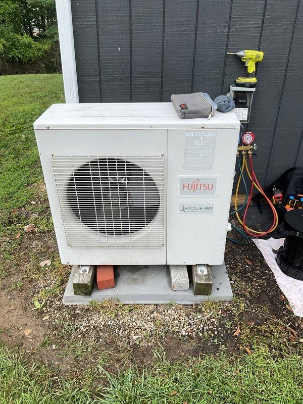 Responded to no cooling complaint on Fujitsu mini-split system serving commercial building. Upon arrival, connected manifold gauges to outdoor condensing unit and confirmed system was low on refrigerant charge. Inspected both outdoor unit located at rear of building and air handlers positioned in attic space. Documented equipment condition with photos showing outdoor unit on concrete pad with proper clearance and ventilation. Communicated diagnostic findings of low refrigerant to customer contact for approval to proceed with leak detection and recharge services.