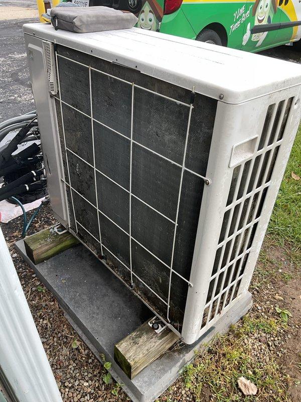 Responded to no cooling complaint on Fujitsu mini-split system serving commercial building. Upon arrival, connected manifold gauges to outdoor condensing unit and confirmed system was low on refrigerant charge. Inspected both outdoor unit located at rear of building and air handlers positioned in attic space. Documented equipment condition with photos showing outdoor unit on concrete pad with proper clearance and ventilation. Communicated diagnostic findings of low refrigerant to customer contact for approval to proceed with leak detection and recharge services.