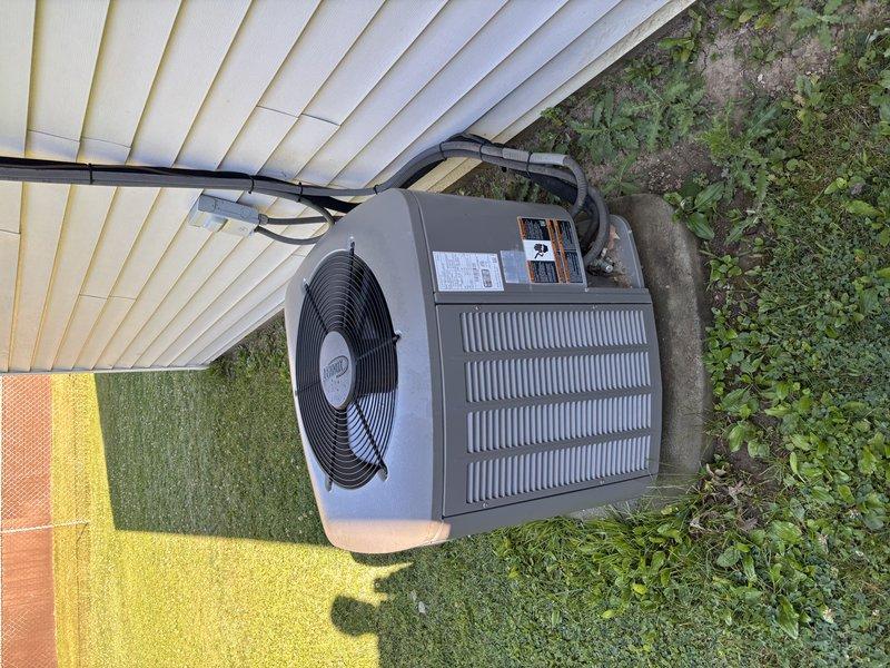 Completed preventive maintenance visit on residential air conditioning system. Performed visual inspection of outdoor condenser unit, noting weathered exterior surfaces and accumulated debris on mesh filter screen requiring attention. Unit operational with fan assembly functioning properly at time of service.