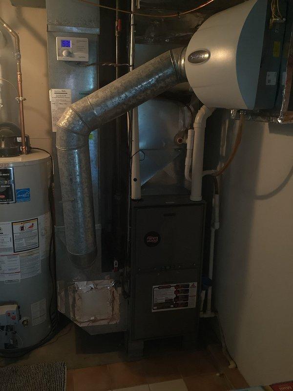 Responded to service call for 9-year-old air conditioning system not producing cold air with thermostat issues. Upon arrival, performed comprehensive diagnostic evaluation of both outdoor condenser unit and indoor air handler system. Inspected outdoor unit mounted on concrete pad, verified electrical connections at disconnect box, and assessed overall equipment condition. Proceeded to basement mechanical room to evaluate indoor furnace/air handler unit and thermostat operation. Diagnosed system malfunction, addressed thermostat communication problems, and restored proper cooling operation to the residential HVAC system.