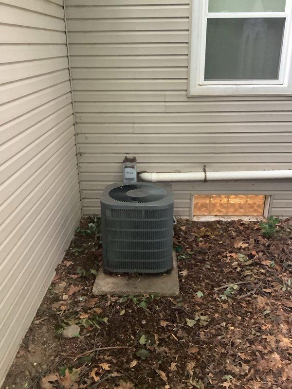 Completed full HVAC system installation including outdoor condensing unit and indoor evaporator coil. Installed Lennox condensing unit on concrete pad in exterior side yard location with proper clearances from building structure. Unit positioned against exterior wall with adequate airflow access through top-mounted circular grille. Connected refrigerant lines between outdoor unit and indoor coil, pressure tested system, and evacuated lines to manufacturer specifications. 

Indoor evaporator coil installed above existing furnace in basement utility area with proper condensate drainage routed through PVC piping to exterior. Integrated new A-coil with existing Lennox furnace ductwork using appropriate transitions and sealed all connections. Installed and insulated refrigerant line set through building envelope, ensuring proper penetration sealing. Verified electrical connections at both indoor and outdoor units meet code requirements. System startup completed with refrigerant charge verif