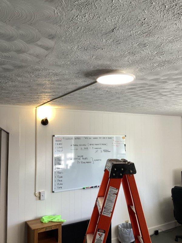Installed wire mold raceway system in two rooms to relocate lighting fixtures from existing wall-mounted positions to center ceiling locations. Mounted new junction boxes at mid-ceiling points, ran surface-mounted conduit from original fixture locations, and installed customer-supplied LED light fixtures with wireless three-way switching capability in room lacking existing switch control.