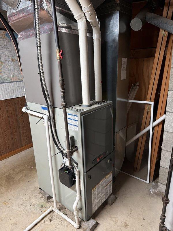 Completed installation of new Lennox air conditioning system with evaporator coil to existing furnace infrastructure. Installed 25-ampere fuses in disconnect box, connected refrigerant lines with proper insulation, and verified all electrical connections to manufacturer specifications. System tested and operational with proper airflow through newly installed A-coil mounted to furnace plenum.