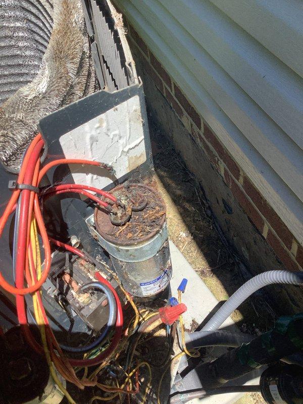 Responded to no-cooling complaint on residential air conditioning system. Upon inspection, found outdoor condensing unit operational with compressor running but failing to produce cool air. Identified severely corroded compressor housing with extensive rust damage compromising system integrity. Refrigerant lines showed signs of age with deteriorated insulation. Diagnosed system failure due to compressor deterioration and likely refrigerant loss. Documented equipment condition with photographs showing rust damage, degraded components, and overall unit wear requiring replacement.
