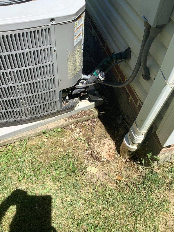 Responded to no-cooling complaint on residential air conditioning system. Upon inspection, found outdoor condensing unit operational with compressor running but failing to produce cool air. Identified severely corroded compressor housing with extensive rust damage compromising system integrity. Refrigerant lines showed signs of age with deteriorated insulation. Diagnosed system failure due to compressor deterioration and likely refrigerant loss. Documented equipment condition with photographs showing rust damage, degraded components, and overall unit wear requiring replacement.
